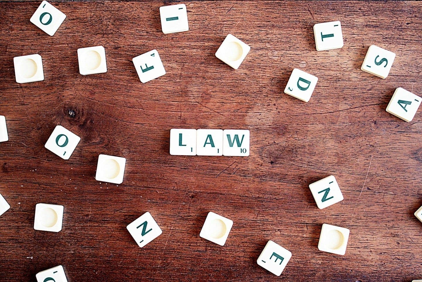Letter tiles spelling LAW on a wooden table