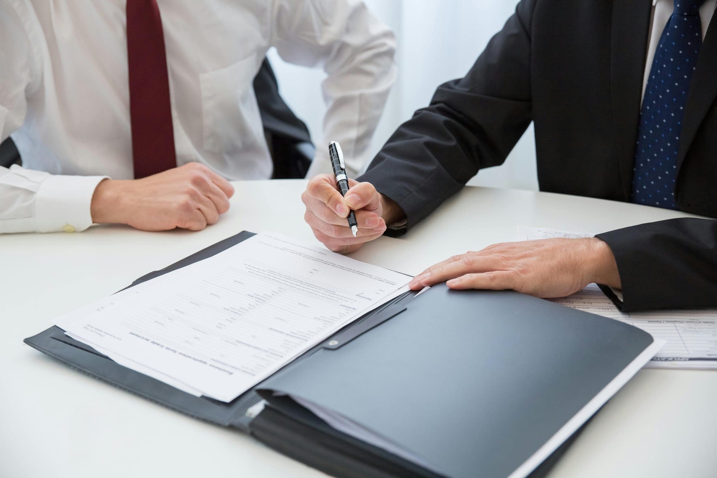 Two professionals reviewing a document in a folder